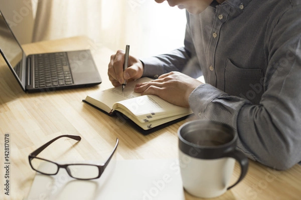 Obraz 机の上で仕事・勉強をする男性