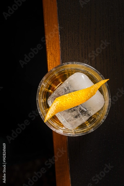 Fototapeta Golden Whiskey Cocktail Ice Cube Citrus Twist Dark Mood