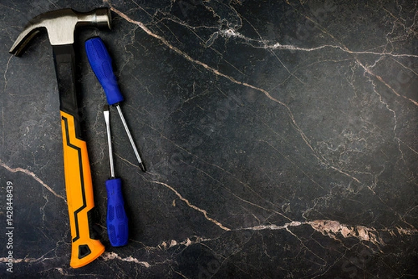 Fototapeta On a dark marble surface, a hammer and a set of screwdrivers are creatively arranged for multiple DIY projects
