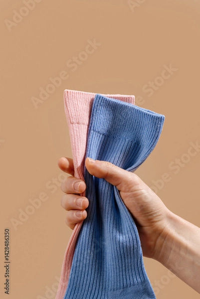Fototapeta Colorful cotton socks in hand showcasing new textile design and patterns