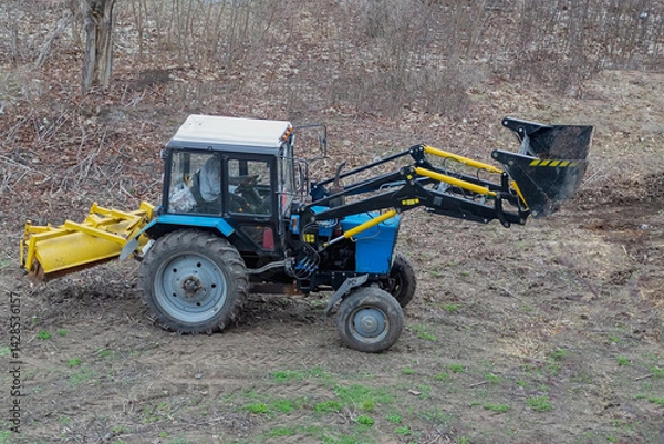 Fototapeta The construction loader on the open site is preparing for cleanup — a symbol of the beginning of an important phase of landscaping work in the park area.