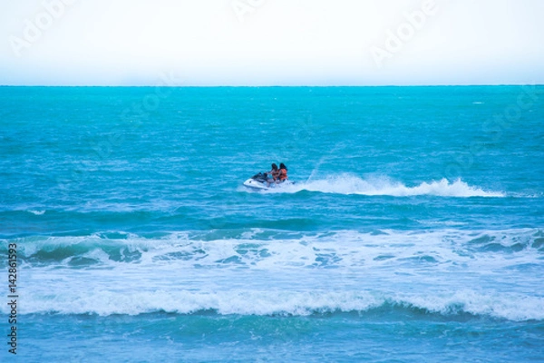 Fototapeta Two girls enjoying speedboat at the beach