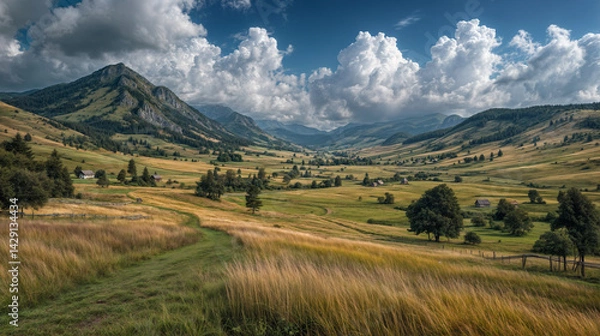 Fototapeta The image depicts a serene landscape with lush green fields, scattered trees, small houses, and towering mountains in the background