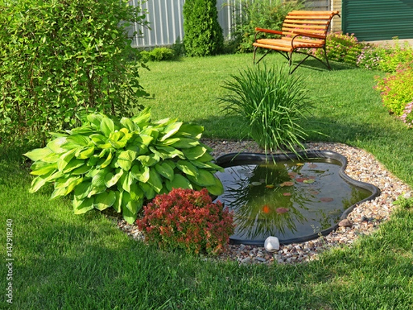 Obraz Small pond in the garden with a lawn and bench