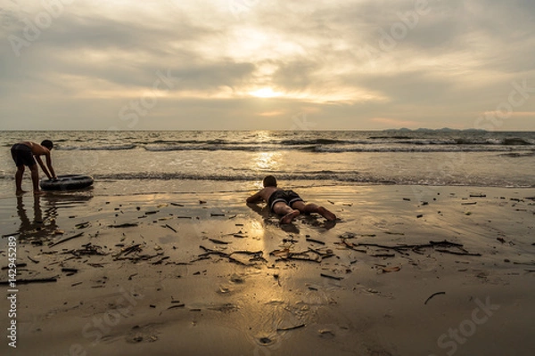 Obraz Two child playing rubber ring on the beach