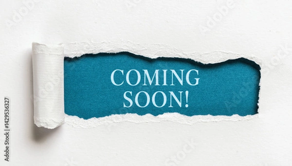 Fototapeta Text coming soon written on blue background behind ripped white paper creative announcement concept for marketing promotions and launch campaigns