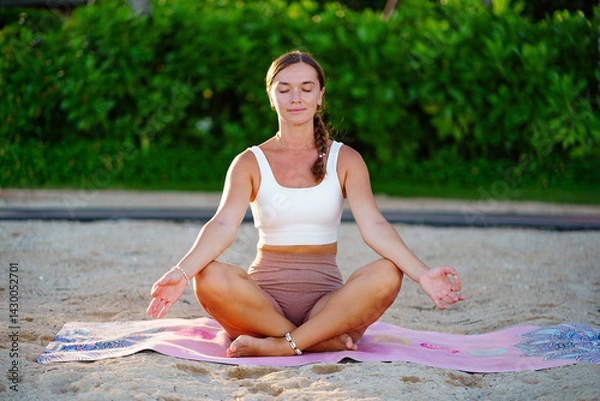 Obraz Concentrated serene young woman with closed eyes in lotus position focus on meditating, stress relief and mindfulness. Mental Well-being and Discipline