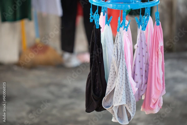 Fototapeta Washed underwear hanging on clothesline with blue clothespin and blurred background.soft picture, selective focus