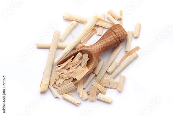 Obraz A wooden scoop filled with organic Lemongrass (Cymbopogon flexuosus), placed on a heap of lemongrass, isolated on a white background.
