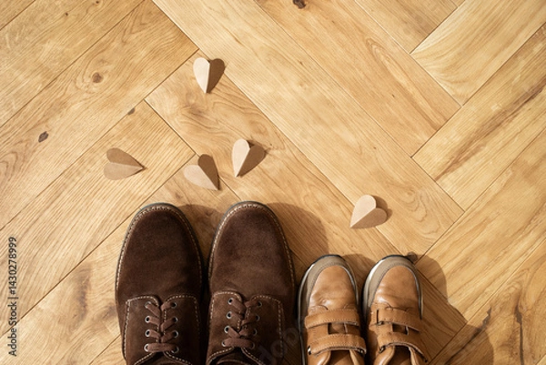 Fototapeta Concept Father day greeting card. Man and children shoes, craft paper hearts on the wooden oak parquet flooring background top view.
