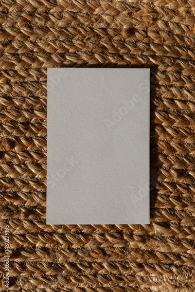 Fototapeta Empty paper card with sunlight shadows on natural jute background. Aesthetic composition for minimalistic brand template in flat lay style.