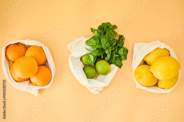 Obraz Colorful fruits and herbs are arranged in reusable cloth bags on a pastel background, highlighting the importance of eco-friendly grocery shopping and healthy eating habits.