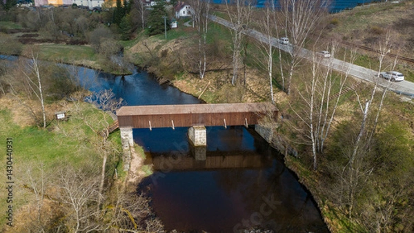 Fototapeta The picturesque covered wooden bridge Rechle near Lenora in the Šumava mountains – a unique national cultural monument - historic bridge with a wooden deck and stone pillars