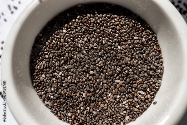 Fototapeta close-up of organic chia seeds on a white background, rich in fiber and antioxidants, supporting digestion and health. superfoods, wellness, healthy eating concept.