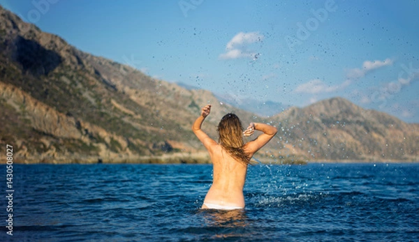 Obraz the woman is having fun in the water making huge splashes