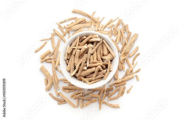 Obraz A bowl of Organic Ashwagandha (Withania somnifera) roots, placed over a heap of whole ashwagandha roots. Isolated on a white background.