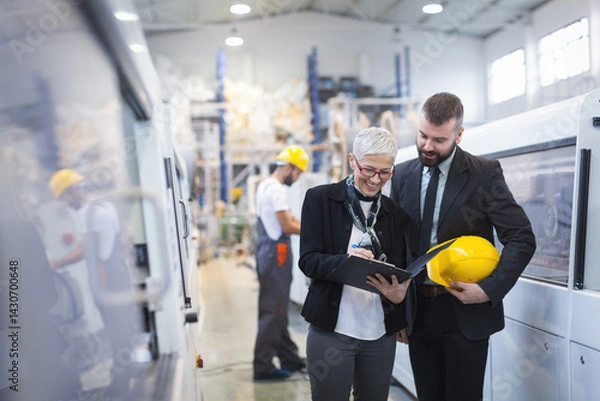 Fototapeta Quality inspectors team and workers at factory using machines