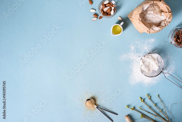 Obraz Baking ingredients for pastry on the blue background. Cooking cakes or bread concept. Top view, copy space.