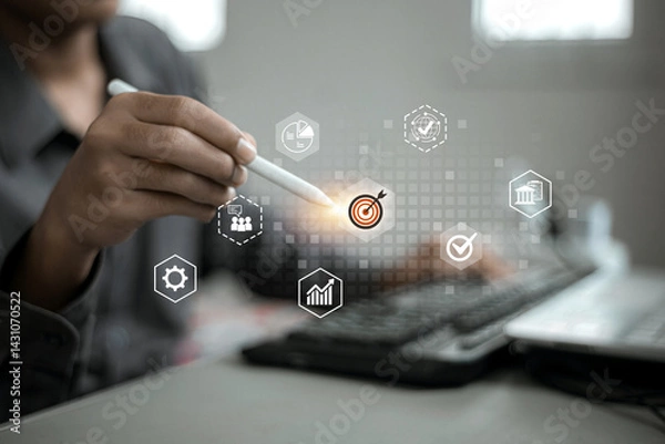 Obraz A digital interface shows icons around a target symbol being tapped with a stylus, suggesting strategic planning or goal setting.