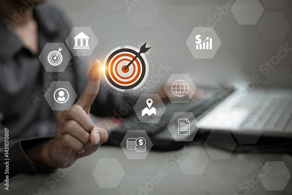 Obraz .A person tapping a central target icon with surrounding business icons, symbolizing centralized goals and digital business tools..