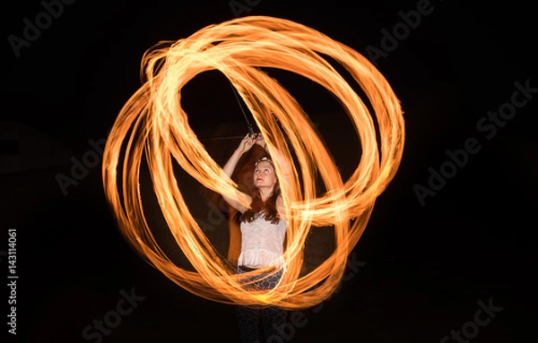 Fototapeta Dancer with flaming fire pois after dark.