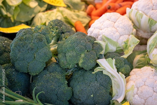 Obraz A bunch of broccoli and cauliflower are displayed in a market