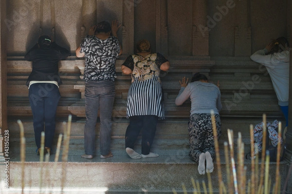 Obraz unidentified peoples pray in a temple in Ho Chi Minh City, Vietnam. A significant number of religions co-exist in Vietnam for centuries.