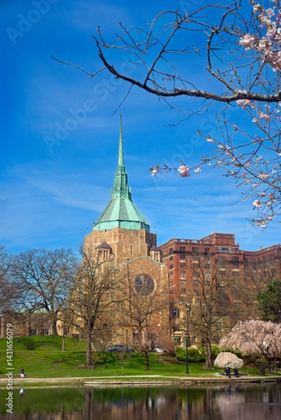 Fototapeta A Cleveland Ohio church popularly known as "the Holy Oil Can" because of its unique steeple, sits above Wade Lagoon in the University Circle district among flowering cherries.