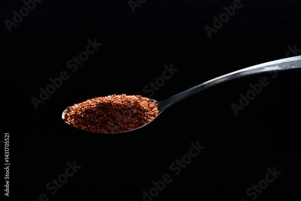 Obraz Close up cayenne spices on spoon isolated on black background.