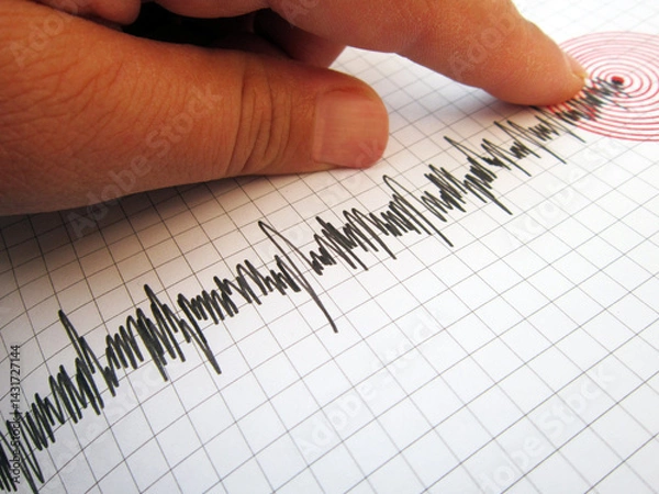 Fototapeta     Seismograph and earthquake. A hand pointing at a seismograph recording the seismic activity of an earthquake                           