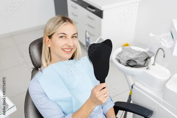 Fototapeta Smiling patient sitting in dentist chair showing perfect teeth