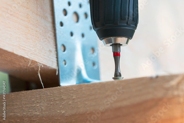 Fototapeta A drill bit is being used to drill a hole in a piece of wood