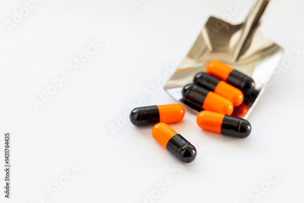 Fototapeta A spoon is used to scoop up a pile of pills