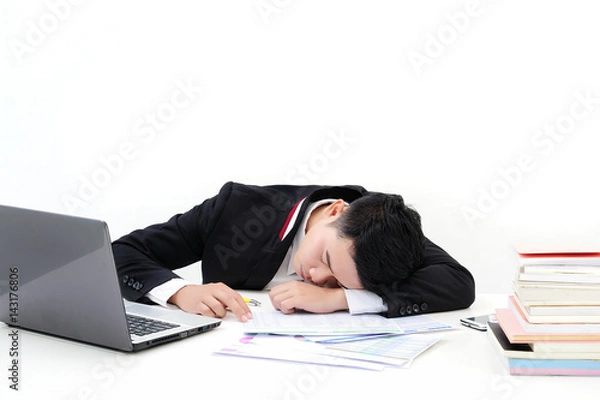 Obraz young asia businessman is sleeping at desk office on white background