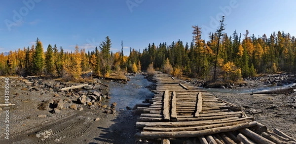 Fototapeta Russia. The Altai Mountains. A dilapidated wooden bridge over the Aktra River, which all-terrain vehicles drive around along the stone riverbed on the way to the ancient glacier of the same name.