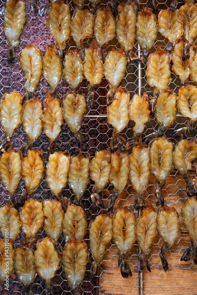 Fototapeta Close-up of Japanese mirin-marinated shrimp drying on a wire rack in Atami Peace Street shopping arcade, showcasing traditional culinary techniques and local seafood culture in a market setting.