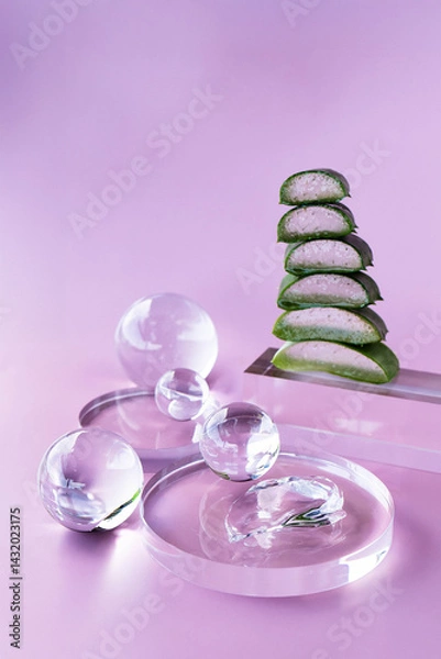 Fototapeta A modern setup showcases aloe slices stacked elegantly alongside serum droplets and glass orbs.