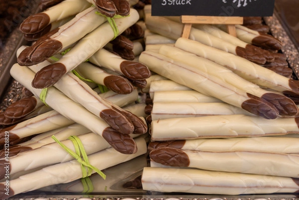 Fototapeta Chocolate vegetables made of different types of chocolate by hand in a candy shop for the spring season chocolate asparagus