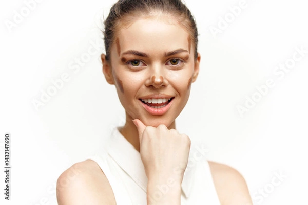Fototapeta Young woman with natural makeup smiling and posing thoughtfully in a bright setting, conveying confidence and positivity.