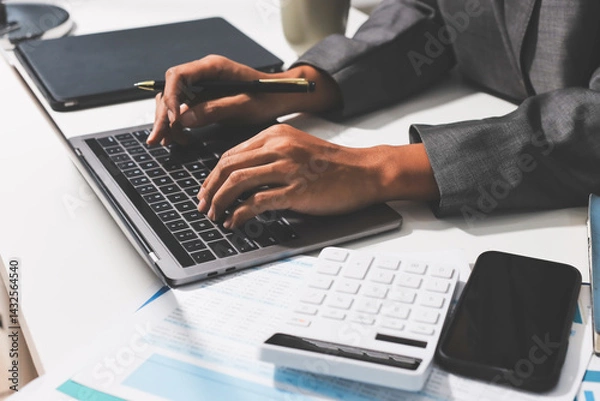 Fototapeta Working from home, Closeup business woman using laptop computer and analyzing financial report.
