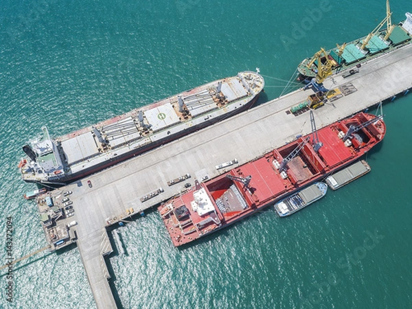 Fototapeta ships vessels are alongside berthed in jetty terminal of port loading and discharging operation general cargo in bulk