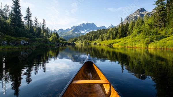 Fototapeta A canoe docked on the edge of a pristine lake, mountain and forest in background