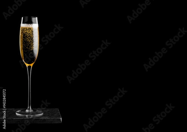 Obraz Elegant glass of yellow champagne with bubbles on black marble board on black background. Space for text