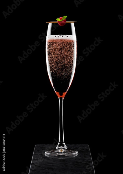 Obraz Elegant glass of pink rose champagne with raspberry on stick on black marble board on black background.