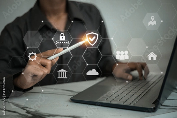 Obraz A man pointing at a digital shield and lock icons representing cybersecurity and user access protection.