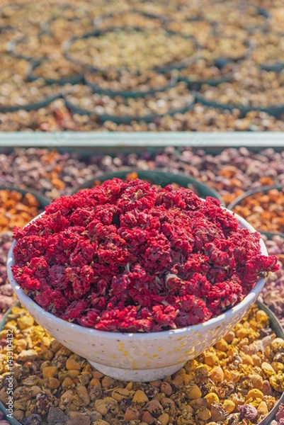 Obraz High angel view of bowl full of red dried flowers in a market in Marrakech. Morocco. Vertically. 