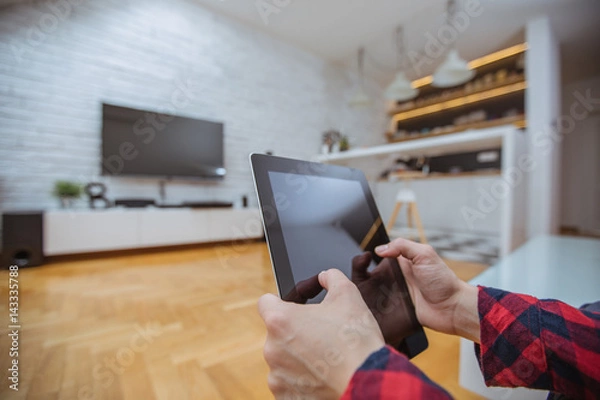 Obraz Close up and part of human hand using digital tablet in living room