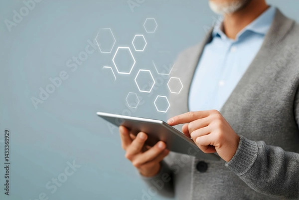 Obraz A man using a tablet with digital hexagonal graphics, symbolizing technology and innovation in a modern setting.