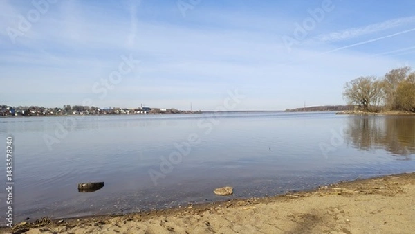 Fototapeta Volga River coast in early spring. Russia, Kostroma. Wide, calm river with mirrored surface