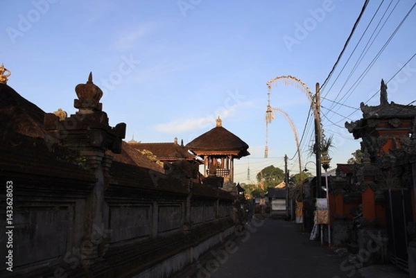 Fototapeta Street in a foreign country with a large building in the background. The street is empty and the sky is blue
